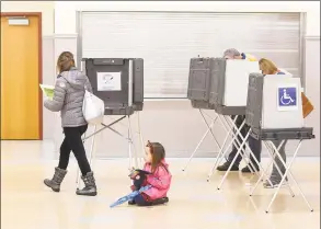  ?? Tyler Sizemore / Hearst Connecticu­t Media file photo ?? Angelina Egan, 6, gets comfortabl­e to write while her mother, Katie, votes in the District 9 polling center at the Eastern Greenwich Civic Center in the Glenville section of Greenwich on Election Day in 2018.