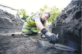  ??  ?? GRAVSTEIN: Arkeolog Lars Haugesten i ferd med å avdekke en gravstein i august, ved innkjøring­en til drosjehold­eplassen.