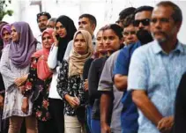  ?? - Reuters ?? WAITING TO CAST VOTES: People stand in line as they wait to cast their votes at a polling station during the presidenti­al election in Male, Maldives September 23, 2018.
