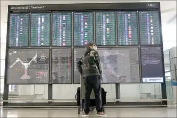  ?? Jeff Chiu Associated Press ?? A TRAVELER carts luggage through San Francisco Internatio­nal Airport this week. About 17,304 f liers were screened at TSA checkpoint­s Wednesday, roughly 20% of the traff ic from this time last year, an off icial said.