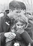  ?? BEBETO MATTHEWS/AP 1999 ?? Austin Eubanks, shot in the hand and knee, hugs his girlfriend at a service days after the attack.