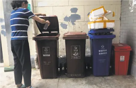  ?? Chen Si / Associated Press ?? Shanghai’s new trash sorting program requires residents to use bins for refuse that is wet, dry, recyclable and hazardous.