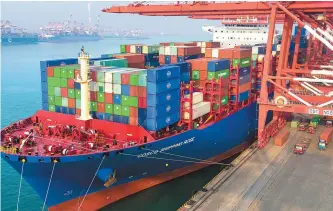  ?? AP-Yonhap ?? Containers are loaded onto a cargo ship at a port in Qingdao in east China’s Shandong province, Jan. 11. China’s trade growth slowed in 2018 as a tariff battle with Washington heated up and global consumer demand weakened.