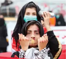  ?? AFP ?? An Iraqi demonstrat­or with makeup to represent violence takes part in an antigovern­ment march in the center of the southern city of Basra on Tuesday.