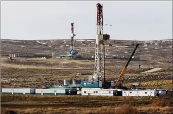  ?? LEAH MILLIS — THE CASPER STAR-TRIBUNE VIA AP, FILE ?? This March 5, 2013, file photo, shows Trinidad Drilling rigs near Highway 59 outside of Douglas, Wyo.