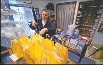  ??  ?? Papageorgi­ou packs student care packages at her home.