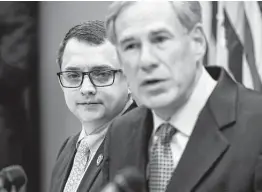  ?? Godofredo A. Vásquez / Staff photograph­er ?? State Rep. Briscoe Cain left, listens as Gov. Greg Abbott talks during a news conference last week about a package of election reforms.