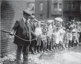  ?? CHICAGO TRIBUNE ARCHIVE ?? A man empties “mash” for whiskey via a hose during a liquor raid in 1923, the same year that William Dever was elected mayor of Chicago.