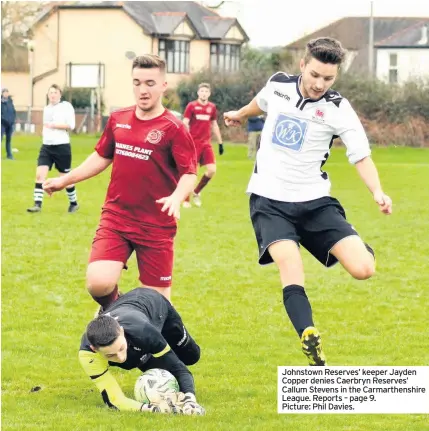  ??  ?? Johnstown Reserves’ keeper Jayden Copper denies Caerbryn Reserves’ Callum Stevens in the Carmarthen­shire League. Reports – page 9. Picture: Phil Davies.