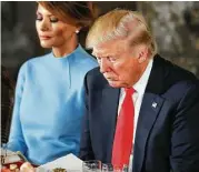  ?? Aaron P. Bernstein / Getty Images ?? President Donald Trump and his wife, Melania, bow their heads in prayer during the inaugural luncheon Friday in Washington, D.C.