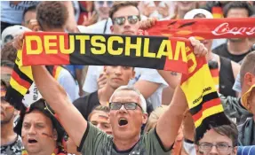  ?? JOHN MACDOUGALL/AFP/GETTY IMAGES ?? Fans of the German soccer team sing the national anthem June 27 in Berlin before a World Cup match against South Korea. The anthem’s reference to the “Fatherland” bothers some people.