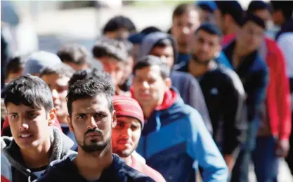  ?? —AP ?? BELGRADE, SERBIA: Migrants queue for food at a park where hundreds of migrants are temporaril­y residing on Thursday, October 6, 2016.