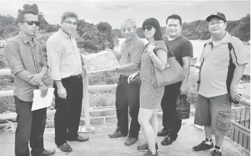  ??  ?? Masing and Watson (third and second left, respective­ly) show the proposed plan for the jungle produce market.