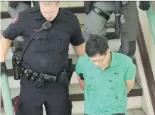  ?? GAVIN YOUNG/FILES ?? Police escort Jin Qing Huang, 42, of Calgary away from the Perpetual Wellness Chinese Medicine Centre last June.