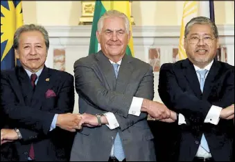  ?? REUTERS ?? US Secretary of State Rex Tillerson (center), acting Foreign Affairs Secretary Enrique Manalo (right) and Malaysian Foreign Minister Datuk Seri Anifah Aman link hands before a working lunch for ASEAN foreign ministers in Washington.