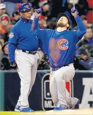  ?? Ezra Shaw Getty Images ?? BEN ZOBRIST reacts next to third base coach Gary Jones after hitting a triple to drive in Anthony Rizzo in a three-run fifth inning for the Chicago Cubs, who tied the World Series, 1-1.