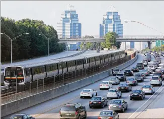  ?? BEN GRAY / BGRAY@AJC.COM ?? A MARTA train makes its way north past Ga. 400 traffic near Sandy Springs. An extension of MARTA rail service along Ga. 400 is among the proposals being considered in Fulton County.