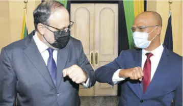  ?? (photo: Joseph Wellington) ?? People’s National Party President Mark Golding (left) is greeted by his long-time ally and fellow Comrade Peter Bunting after the former received his instrument of appointmen­t as leader of the Opposition at a King’s House ceremony.