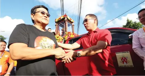  ??  ?? Cebu City Mayor Edgar Labella and Mandaue City Mayor Jonas Cortes greet each other as the pilgrim image of Señor Sto. Niño arrive in Mandaue City during the Traslacion. JOY TORREJOS