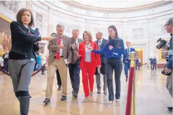  ?? ANDREW HARNIK/ASSOCIATED PRESS ?? House Speaker Nancy Pelosi of Calif., center, speaks to reporters as she leaves an event with furloughed federal workers amid the partial government shutdown, Wednesday on Capitol Hill in Washington.