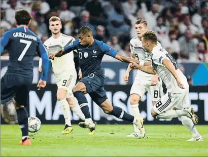  ?? ANDREAS GEBERT / REUTERS ?? El jugador del PSG Kylian Mbappé controla un balón a la carrera frente a tres rivales germanos