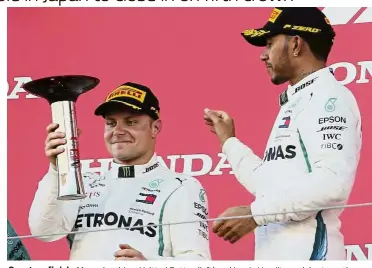  ??  ?? One-two finish: Mercedes driver Valtteri Bottas (left) and Lewis Hamilton celebrate on the podium after the Japan Grand Prix yesterday. — AP