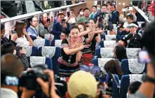  ?? LI JIAXIAN / CHINA NEWS SERVICE ?? Dancers wearing ethnic clothing entertain people aboard a train as the China-Laos Railway line began cross-border passenger service on Thursday.