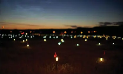  ?? Photograph: Geoff Robins/AFP/Getty Images ?? Lights and flags mark the spots where 751 human remains were recently discovered in unmarked graves at the site of a former residentia­l school in Saskatchew­an.