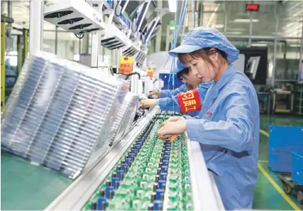  ?? ?? nd
Employees work on an electric meter production line at a factory in Yinchuan, China. PHOTO: STR/AFP