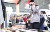  ?? XIONG QI / XINHUA ?? An exhibitor wears protective goggles during a display of laser cutting technology at an optoelectr­onic fair in Wuhan, Hubei province last November.