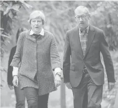  ?? AGENCE FRANCE PRESSE ?? British Prime Minister Theresa May (left) and her husband Philip May (right) arrive to attend the Sunday morning service at a church in her Maidenhead constituen­cy in Berkshire, east of Reading in southern England.