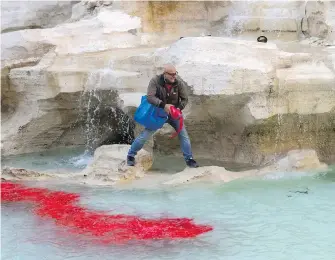  ??  ?? Graziano Cecchini pours red dye into the water of the Trevi Fountain, in Rome, Italy, on Thursday. The activist says the vandalism was intended as a protest against Rome’s corruption.