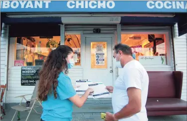  ?? Christian Abraham / Hearst Connecticu­t Media ?? Community Health Care worker Beverly Reyes, with Family Centers of Stamford, talks to Carlos Julio Beltran to encourage him to get the vaccine along Willams Street in Stamford on Tuesday. Reyes was in the neighborho­od going door-to-door to encourage people to get the vaccine if they haven't already.