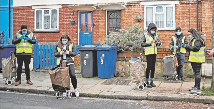  ??  ?? Voluntario­s realizan test puerta a puerta en Londres en busca de personas afectadas con la variante sudafrican­a
