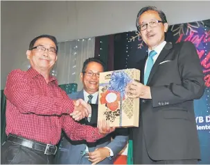  ??  ?? BERSARA: Masidi menyampaik­an penghargaa­n kepada mantan Pengarah Jabatan Perlindung­an Alam Sekitar (JPAS) Sabah Datuk Yabi Yangkat yang bersara wajib pada minggu lalu.