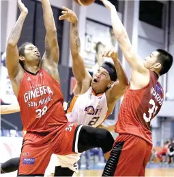  ??  ?? DIFFICULT SHOT – Meralco’s Rey Hugnatan, center, tries to get the ball past the defense of Barangay Ginebra San Miguel’s Joe Devance, left, and Aljon Mariano during Sunday’s PBA game at the AUF Gym powered by Smart 5G. Ginebra won 105-91. (PBA Images)