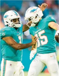  ?? WILFREDO LEE/AP ?? Dolphins QB Tua Tagovailoa, left, and wide receiver River Cracraft celebrate after Cracraft caught a pass in the end zone for a touchdown during a preseason game against the Eagles on Aug. 27 in Miami Gardens.