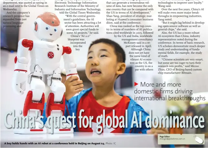  ??  ?? A boy holds hands with an AI robot at a conference held in Beijing on August 24.