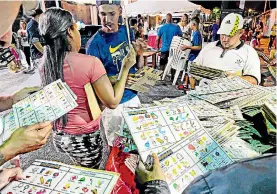  ?? ?? Los apostadore­s selecciona­n minuciosam­ente los cartones de bingo buscando el que les pueda dar un gran premio.