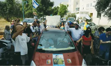  ?? (Amir Cohen/Reuters) ?? ATTORNEY YORAM SHEFTEL (in car, front left) accompanie­s former soldier Elor Azaria (in rear seat, not seen) as he leaves his home in Ramle yesterday on the way to military prison.