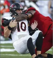  ?? Arkansas Democrat-Gazette/MITCHELL PE MASILUN ?? Daniel Santacater­ina (10) gets sacked by Arkansas State defensive end Ronheen Bingham (8) during their game Saturday night in Jonesboro.