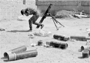  ??  ?? A Kurdish fighter from the People’s Protection Units (YPG) fires a 120 mm mortar round in Raqqa, Syria. — Reuters photo