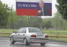  ?? MUSA SADULAYEV/AP ?? A car drives past a billboard of Russian President Vladimir Putin that reads: “For Russia” in Grozny on Saturday. Red Soviet flags and orange-and-black striped military ribbons are on display in cities and towns.