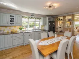  ??  ?? The kitchen measures about 16ft square and has painted wooden cabinets, with a separate utility