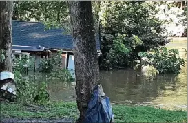  ?? PHOTO BY ROK H. HYON ?? Rok H. Hyon posted this photo on Facebook and wrote the Perkiomen Creek’s floodwater­s pushed the house off 9-foot pylons into the water where it was carried downstream until it was caught up ion some trees.