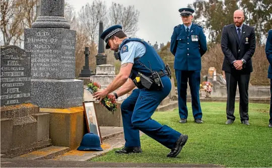  ??  ?? Constable Nathan Bobbette lays a wreath at the grave of Constable James Dorgan, the only police officer to have been killed in the line of duty in South Canterbury.