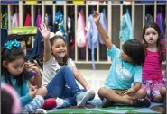  ?? NWA Democrat-Gazette/BEN GOFF • @NWABENGOFF ?? Abigail Altorre (from left), Xavi Quiros and Isabel Copeland raise their hands to ask questions Wednesday while getting to know their first-grade teacher Kayla Wildenborg (not pictured) on the first day of school at Russell D. Jones Elementary in Rogers.