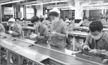  ?? HUANG BAOGUO / XINHUA ?? Employees work at a Galanz production facility in Shunde, Guangdong province, on Feb 10.