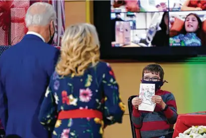  ?? Carolyn Kaster / Associated Press ?? A Children’s National Hospital patient displays a lantern to President Joe Biden and wife Jill as they visit patients on Friday in Washington, D.C. It’s tradition for first ladies to visit the hospital at Christmast­ime, but Biden’s visit was a surprise.