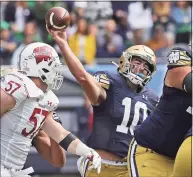  ?? Jonathan Daniel / TNS ?? Notre Dame quarterbac­k Drew Pyne passes over Wisconsin’s Jack Sanborn during last Saturday’s game in Chicago.